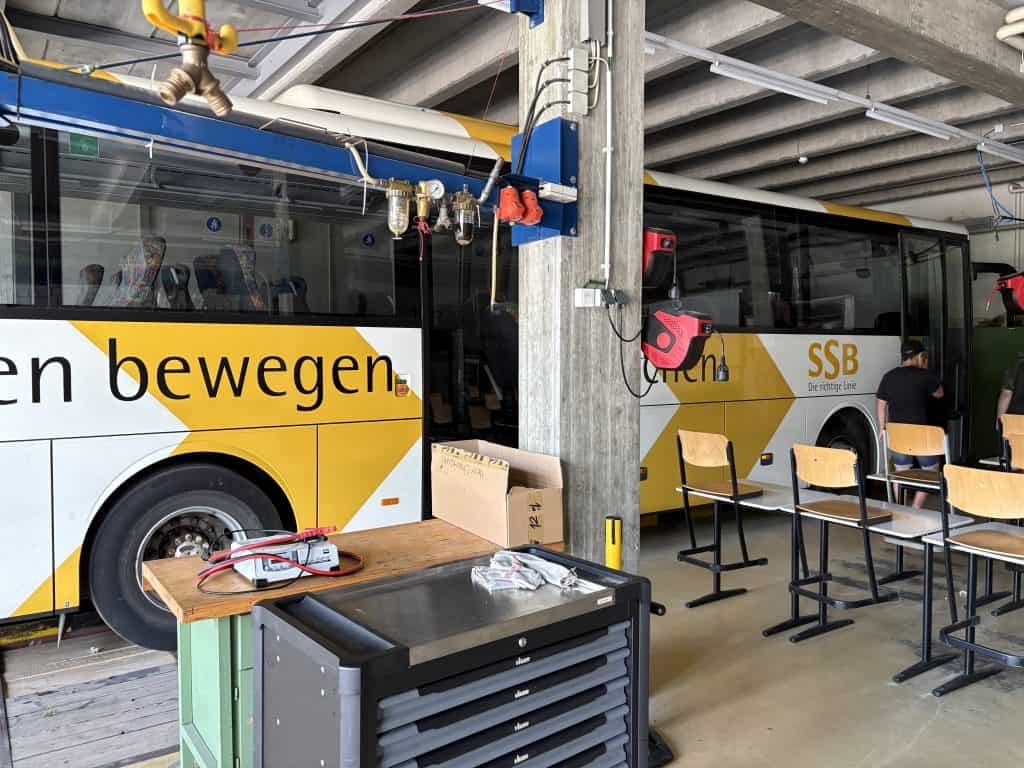 Ein Bus in einer Werkstatthalle, im Vodergrund Werkzeugwagen