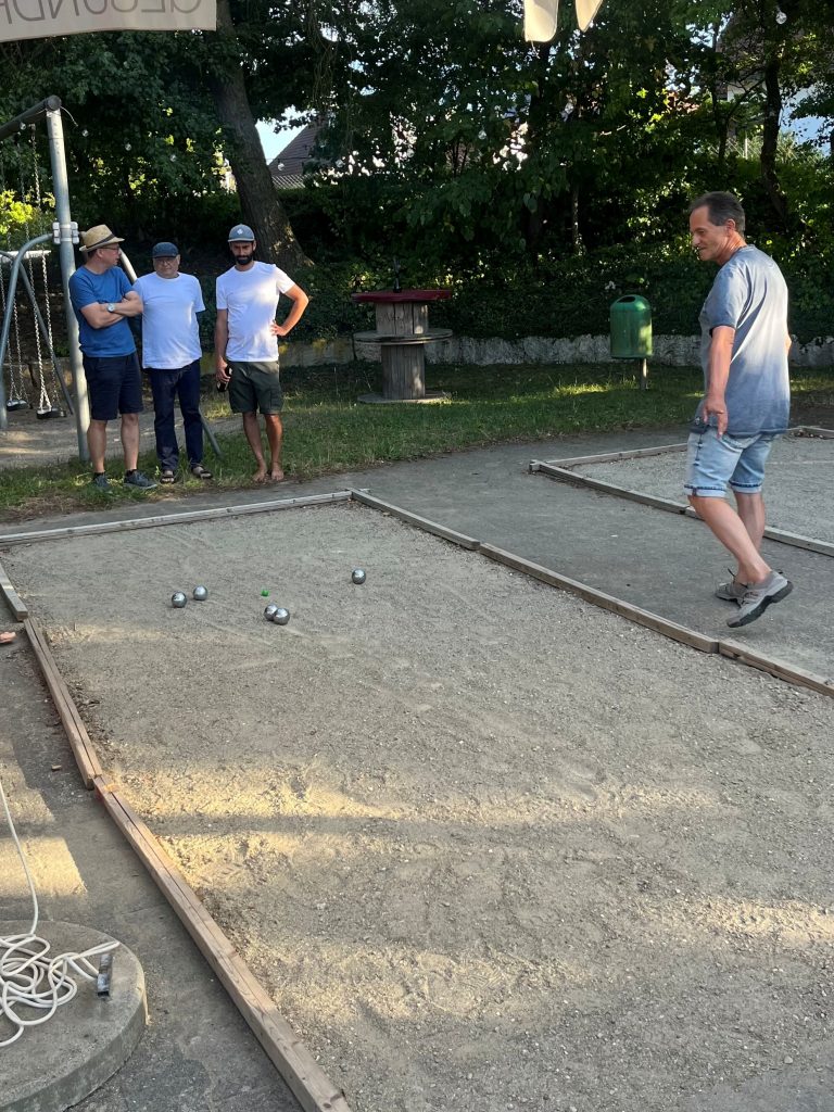 Kugeln liegen auf einer Boule-Bahn.