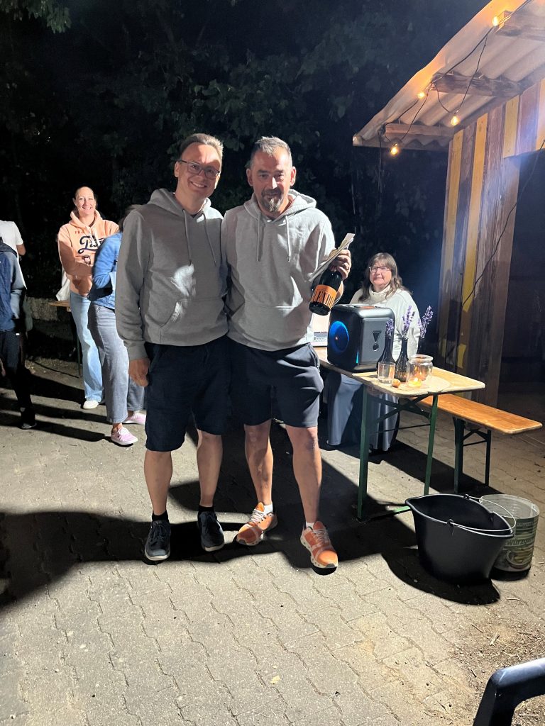 Die Gewinner des Abend-Boule-Turniers mit einer Sektflasche.